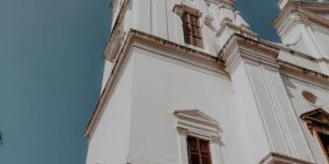 View of the iconic Se Cathedral tower showcasing colonial architecture under a clear sky in Goa, India.