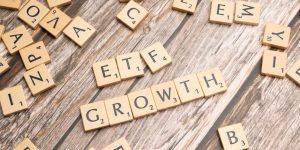 Wooden tiles spelling ETF growth on a wooden surface, symbolizing investment strategy.