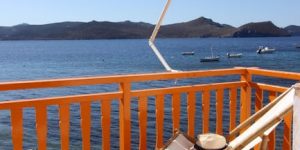 Orange balcony overlooking the sea in Klima, Greece, perfect for summer relaxation.